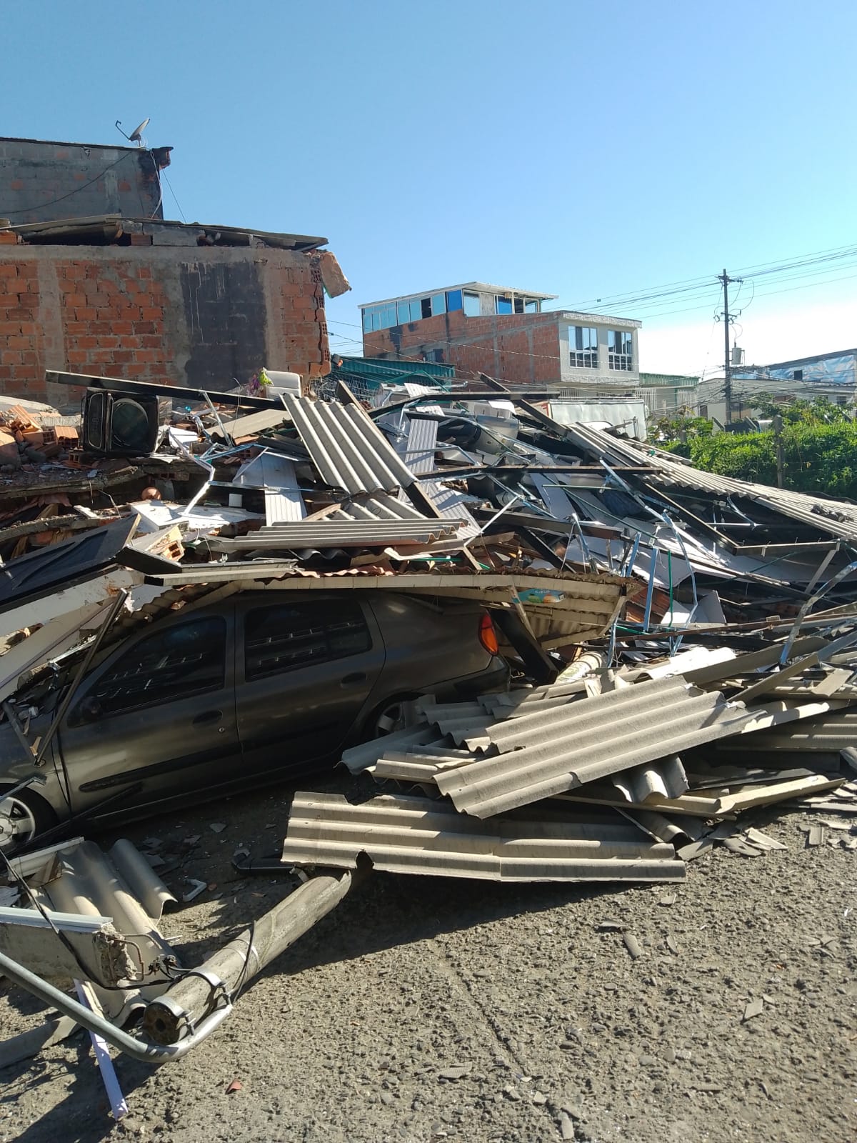 A vehicle trapped beneath collapsed roofing and debris after the Colombia earthquake