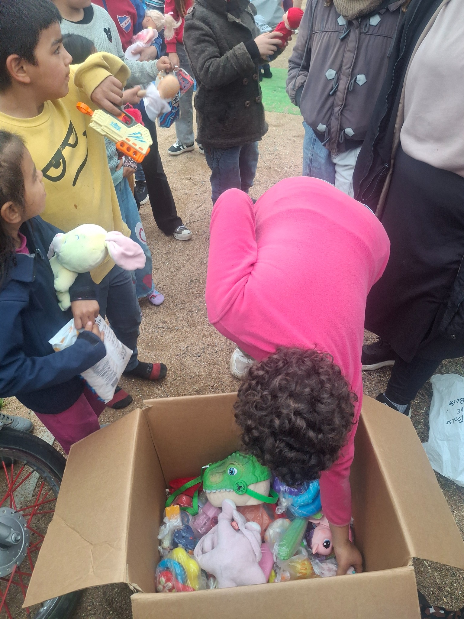 Children selecting toys and donated items prepared for distribution.